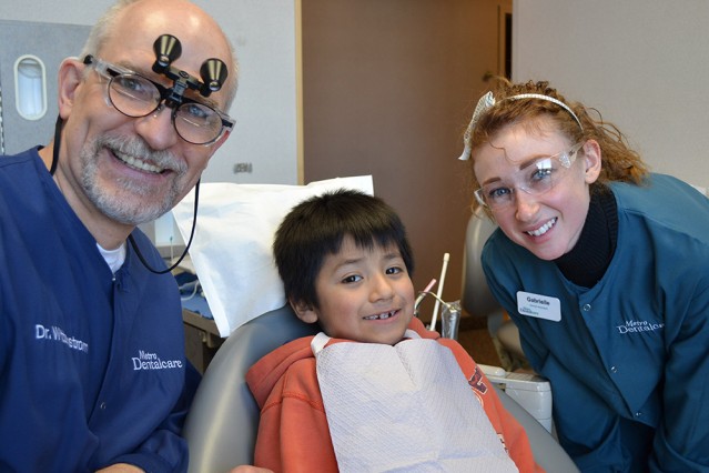 Give Kids a Smile Dentists with Patient boy receiving a free dental visit